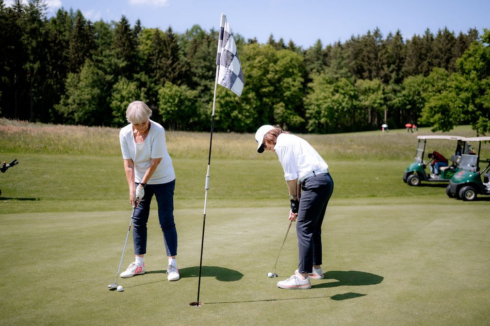 Zwei Frauen spielen Golf.