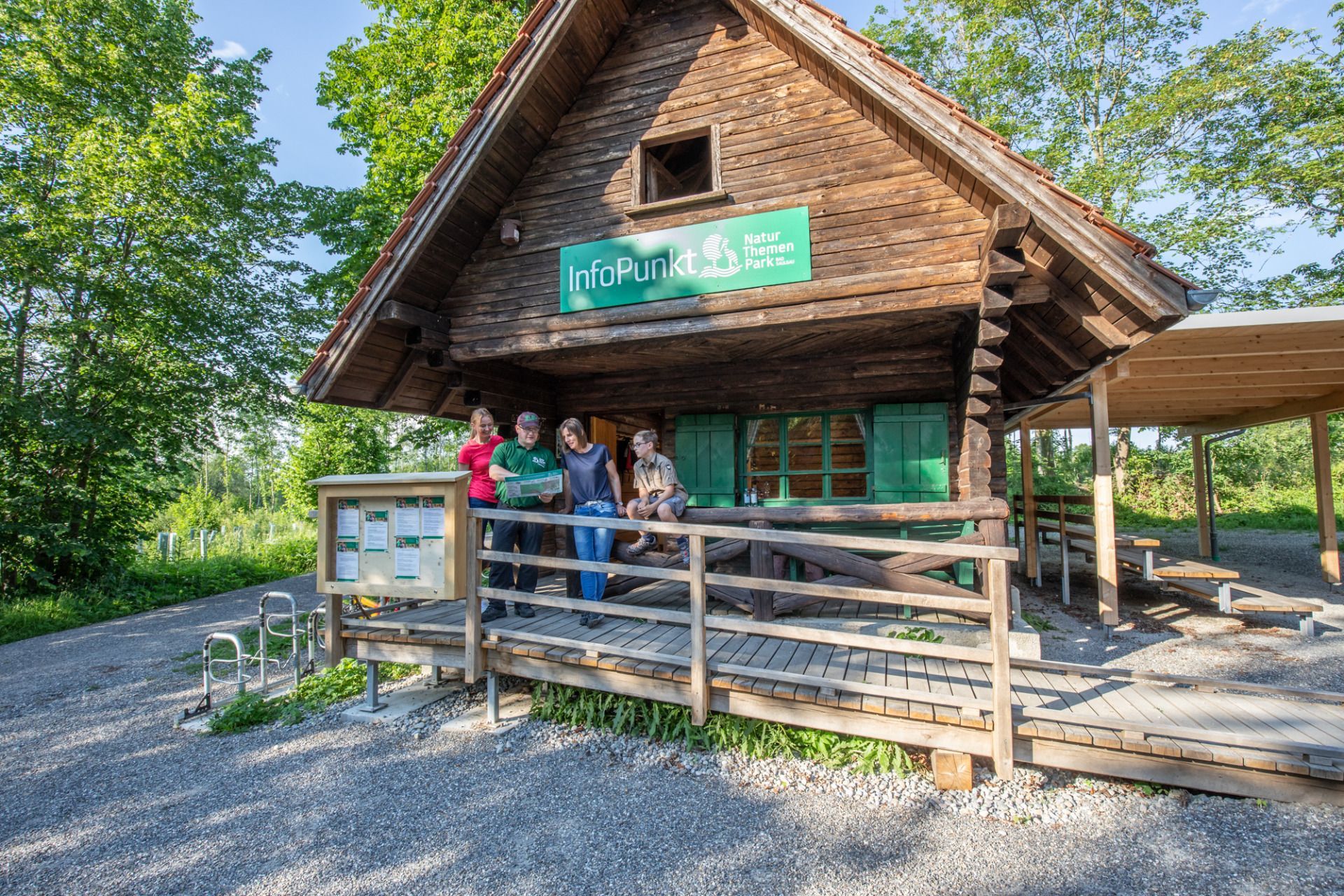 Familie vor einer Blockhütte im Themenpark